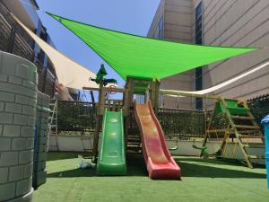 a playground with a slide and a green canopy at Rama Palace Hotel in Casalnuovo di Napoli