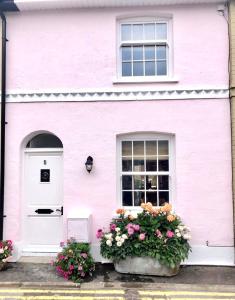 a pink house with flowers in front of it at Stylish & Cosy Boutique Townhouse 1 bedroom, 1 sofa bed - sleeps 4 in Christchurch