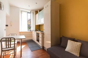ein Wohnzimmer mit einem Sofa und einem Tisch sowie eine Küche in der Unterkunft YouHosty - San Gottardo 13 in Mailand