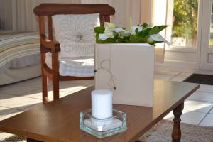 a candle and a vase of flowers on a table at La Maison de la Rose in Étretat