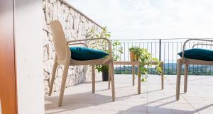 two chairs and a table on a balcony at Encanto Agriturismo & Private SPA in Visogliano