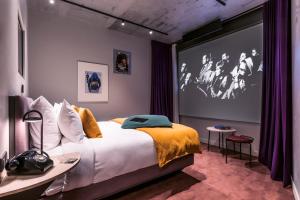 a bedroom with a bed and a large screen at Hotel Paradiso in Paris