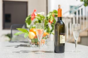 una botella de vino sentada en una mesa con dos copas en Guest House Dada, en Dubrovnik