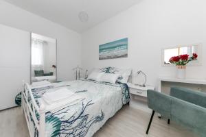 トロギールにあるApartments Zajcのベッドと机のある白い寝室