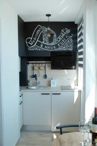 a kitchen with white cabinets and a sign on the wall at Apartmani Donata in Rijeka