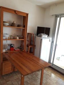 濱海聖皮埃爾的住宿－Studio - Les Hauts d'Azur，厨房配有木桌和冰箱。