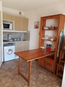 濱海聖皮埃爾的住宿－Studio - Les Hauts d'Azur，厨房配有木桌和洗衣机。