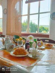 uma mesa com pequeno-almoço de croissants e laranjas em B&B PASSO DEL FALCO em Sorianello