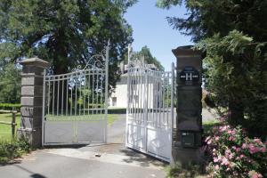 ein Tor mit einer Uhr davor in der Unterkunft HOSTELLERIE LA BRUYERE in Chalvignac