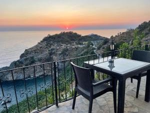 een tafel en stoelen op een balkon met uitzicht op de oceaan bij Blue Lagoon Village in Gazipasa