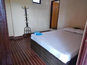 a bedroom with a bed with a cross on the wall at Green Tree in Chitwan