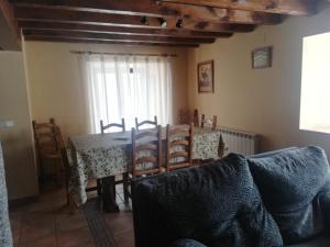a living room with a table and chairs and a couch at Casa Rural del Chopo in La Aliseda de Tormes