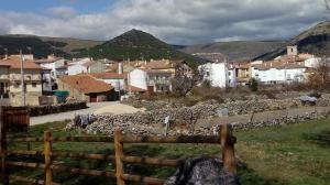 a village with houses and a fence in the foreground at Casa Rural del Chopo in La Aliseda de Tormes