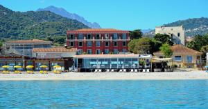 un hotel su una spiaggia con acean gmaxwell di Hôtel Liberata & Spa a LʼÎle-Rousse