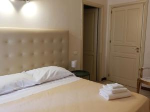 a bedroom with a bed and a dresser at Landolina Palace Hotel in Noto