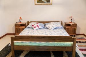 - une chambre avec un lit en bois et 2 tables de chevet dans l'établissement Kuća za odmor Jagnjić, à Josipdol