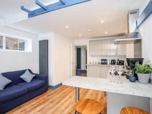 a kitchen and living room with a blue couch at Ty Coets Coach House in Caernarfon