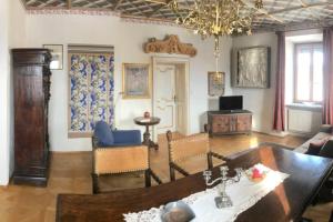 een woonkamer met een tafel en een kroonluchter bij In einer Wohnung durch die Jahrhunderte in Feistritz an der Drau