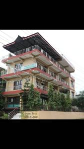 un grande edificio con alberi di fronte di Green Tree a Chitwan