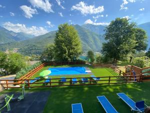 an outdoor swimming pool with mountains in the background at Le Terrazze sul Lago - Ledro House in Pieve Di Ledro