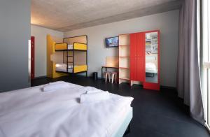 a bedroom with a white bed and a table at MEININGER Hotel Bordeaux Gare Saint-Jean in Bordeaux