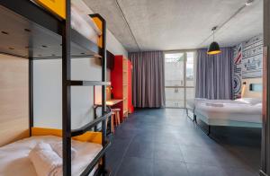 a room with two bunk beds and a hallway at MEININGER Hotel Bordeaux Gare Saint-Jean in Bordeaux