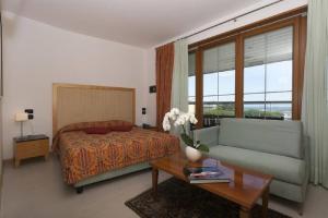 una camera da letto con un letto, un divano e un tavolo di Hotel Centrale a Lido di Jesolo