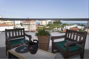 a balcony with two chairs and a table with wine glasses at Hotel Centrale in Lido di Jesolo +24 photos