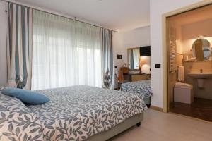 a hotel room with a bed and a bathroom at Hotel Centrale in Lido di Jesolo