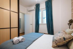 een slaapkamer met een bed met handdoeken erop bij Feijóo Suite Apartment in Sevilla