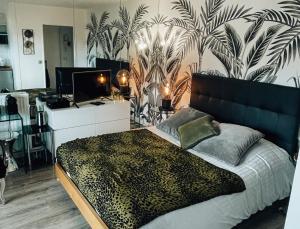 Beautiful modern fully furnished studio في لوفالوا بيريه: غرفة نوم مع سرير بحائط مطبوع فهد