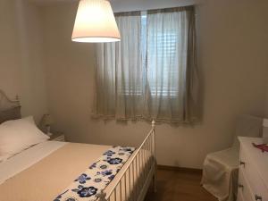 um pequeno quarto com uma cama e uma janela em Appartamento Verde Golf em Miglianico