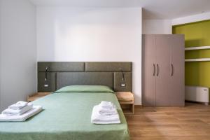 1 dormitorio con 1 cama verde y 2 toallas en Giorgi Design Homes I, en Bolonia