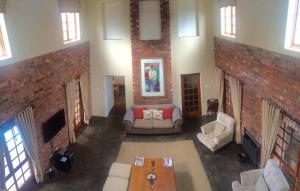 a living room with a couch and a brick wall at Protea Lodge and Cottage- NO LOADSHEDDING in Port Elizabeth