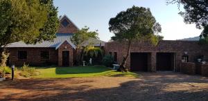 a brick house with a yard with a driveway at Protea Lodge and Cottage- NO LOADSHEDDING in Port Elizabeth