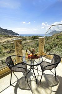 einen Tisch und zwei Stühle auf einem Balkon mit Aussicht in der Unterkunft Albatros Studios & Apartments in Plakias