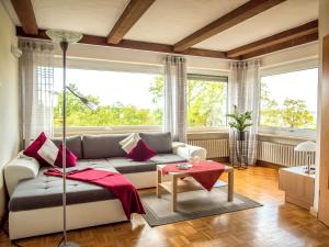 uma sala de estar com um sofá e uma grande janela em Kirschberghof Gästehaus und Weinverkauf em Sommerhausen