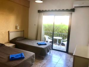 a hotel room with two beds and a balcony at Carina Hotel Apartments in Ayia Napa +48 photos