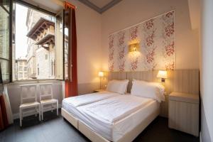 1 dormitorio con cama blanca y ventana en B&B Repubblica, en Florencia