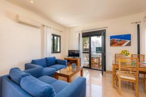 a living room with blue couches and a table at Can Joan in Pollença
