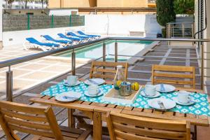 a table and chairs with a meal on a patio with a pool at Can Joan in Pollença