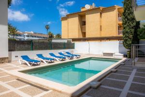 una piscina con tumbonas y un edificio en Can Joan, en Pollensa