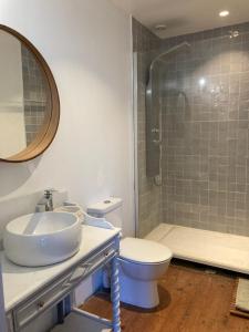 a bathroom with a sink and a toilet and a shower at Maison Paisible au coeur des Pyrénées in Igon +11 photos
