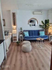 a living room with a blue couch and a table at Apartment Fuengirola Carvajal beach front Málaga Spain in Fuengirola