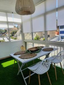 a table and chairs in a room with windows at Apartment Fuengirola Carvajal beach front Málaga Spain in Fuengirola