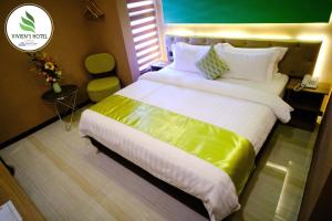 a bedroom with a large bed with a yellow blanket at Vivien's Hotel in Mactan