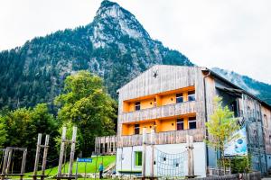 ein Gebäude mit einem Berg im Hintergrund in der Unterkunft Jugendherberge Oberammergau in Oberammergau