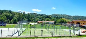 a batting cage in a field with trees in the background at Apartamentos El Castañeu in Corao