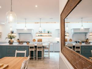 a kitchen with blue cabinets and a wooden table at Fern Bank in Penrith