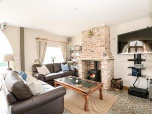 a living room with a couch and a fireplace at The Old Smithy in Horncastle
